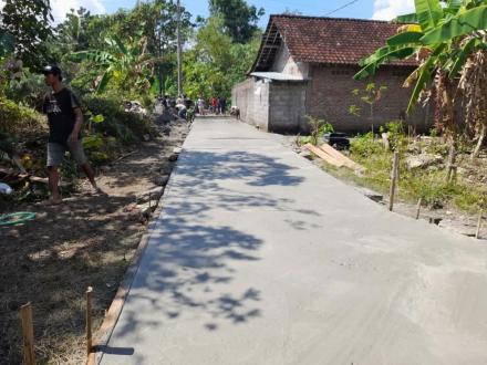 Bergotong royong melaksanakan pembangunan infrastruktur corblok jalan.